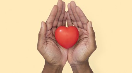 Hands cupping heart in love and relationship concept